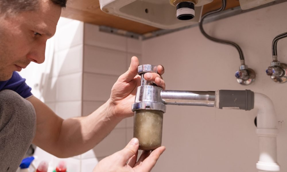 caucasian-male-plumber-fixing-a-sink-in-the-bathro-2024-03-04-19-50-03-utc