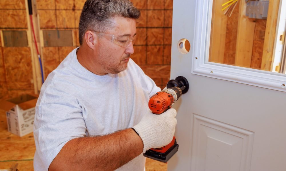 Installing lock doorknob with screwdriver by professional locksmith