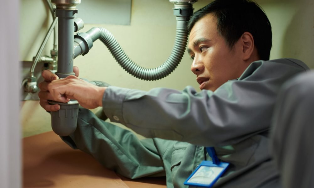 Plumber Cleaning Clogged Pipe